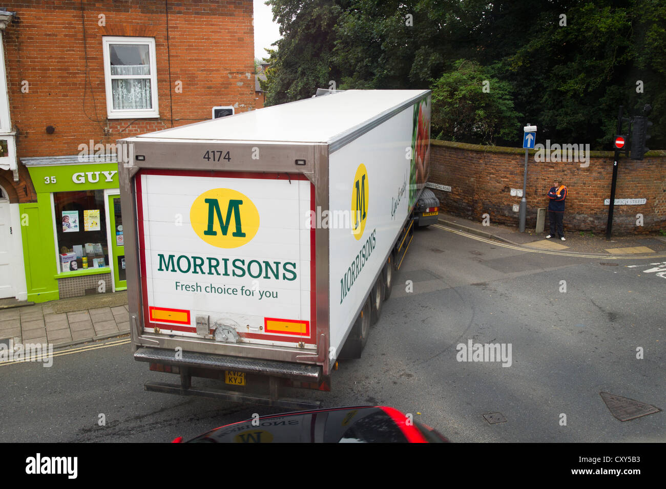 A Morrisons delivery truck negotiating a tight corner in a small English town Stock Photo
