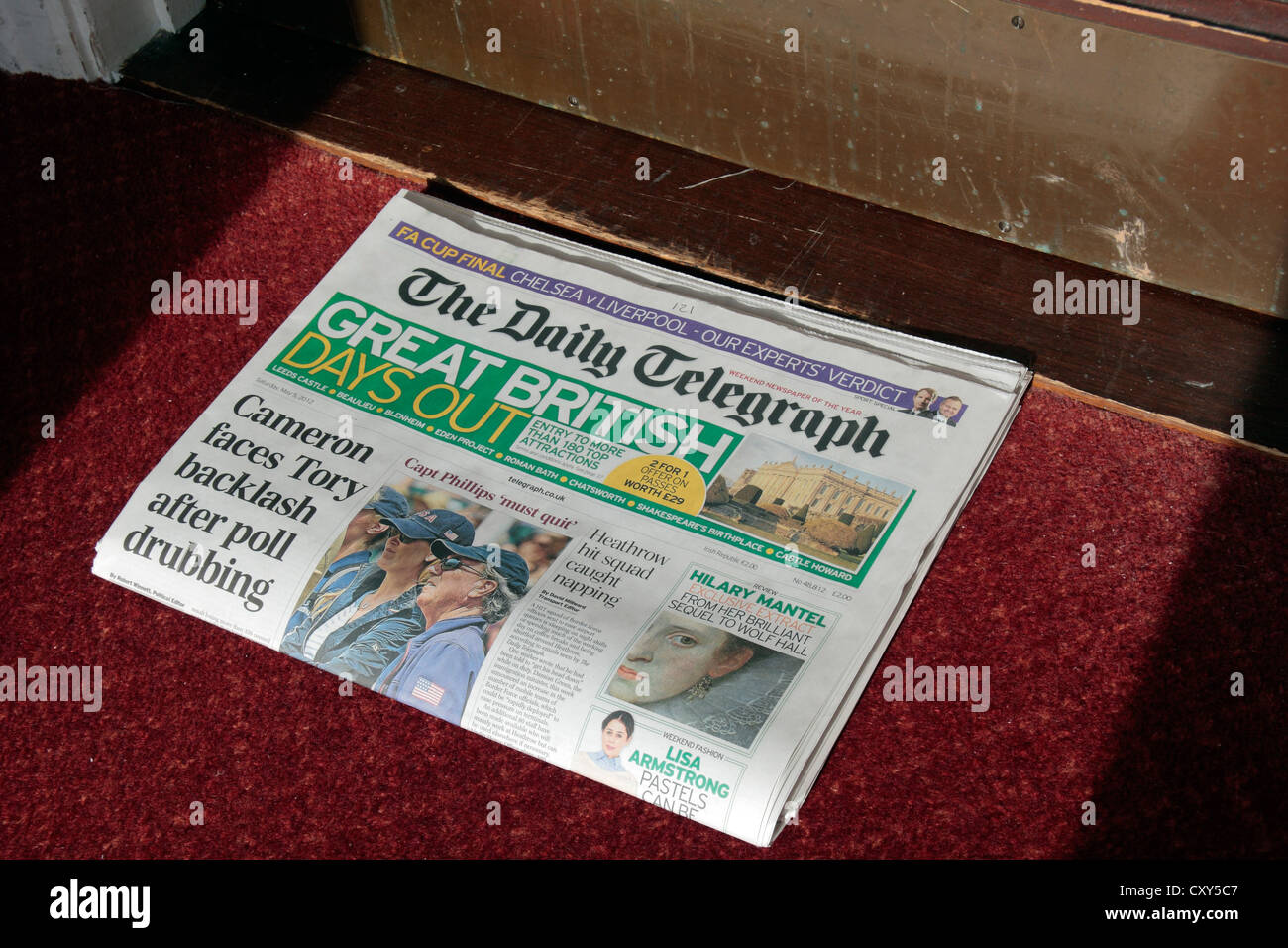 The Daily Telegraph British broadsheet newspaper sitting on a mat outside a hotel room door. Stock Photo
