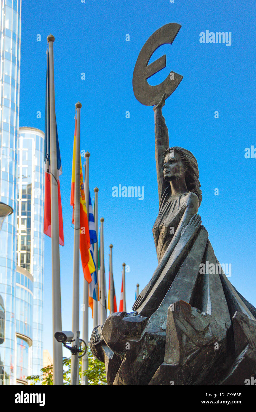 Europa holding a Euro symbol, outside the offices of the European Parliament, Brussels, Belgium (European flags in background) Stock Photo