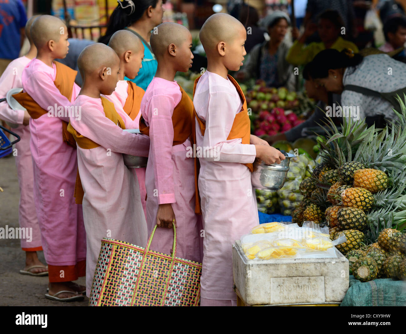 Morning scene in Kengtung, Myanmar. Nuns lining up for alms in a local market. Stock Photo