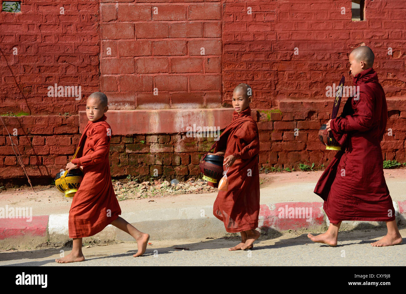 Monks in Myanmar waiting for alms. Stock Photo