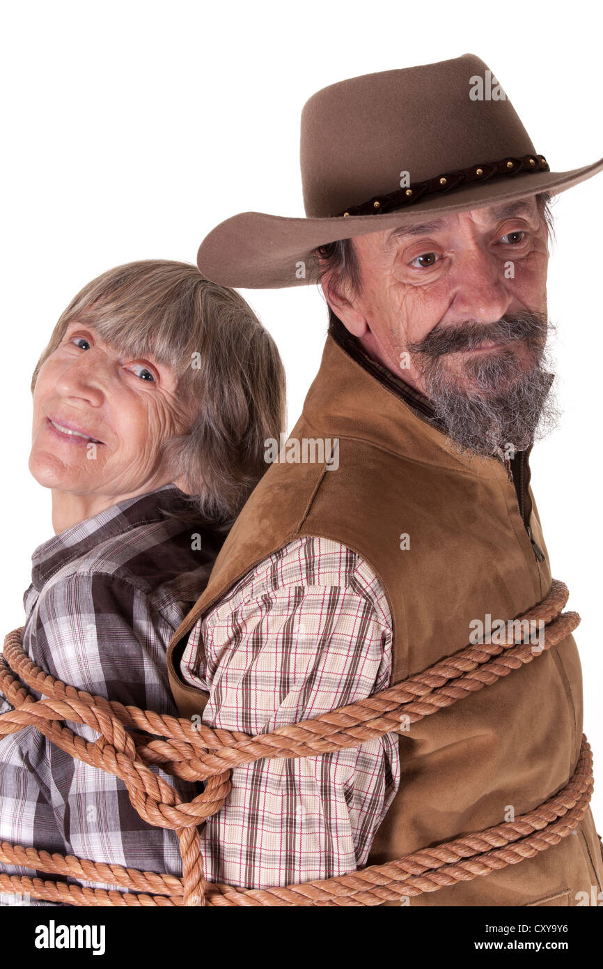 elderly cowboy and woman roped together Stock Photo