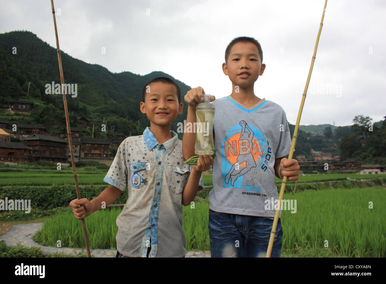 Children who caught a fish in the rice paddy. Xijiang Miao Villagem Guizhou, China. Stock Photo