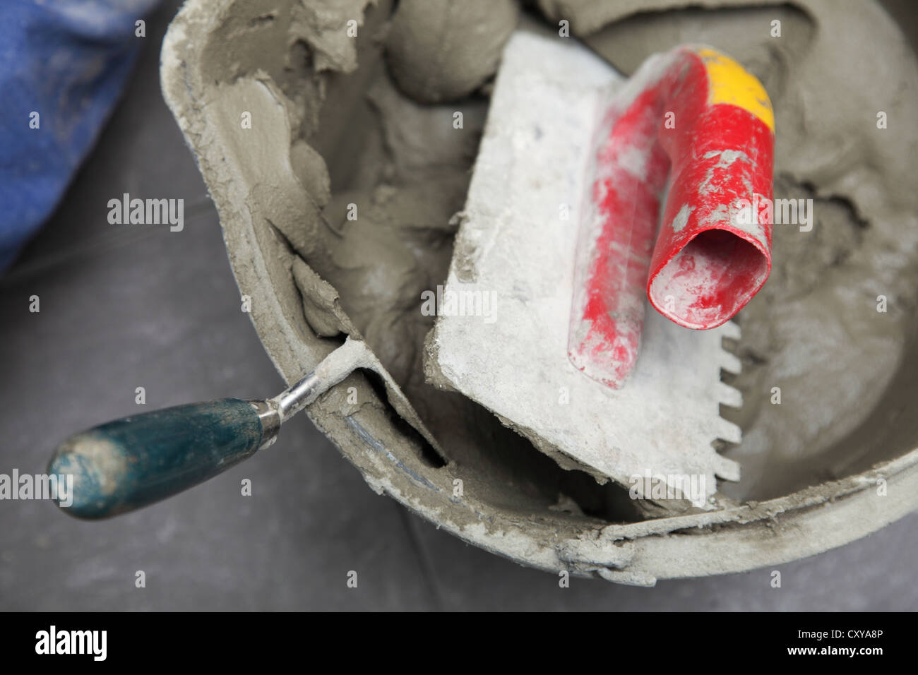 mortar on wall construction notched trowel work tools Stock Photo