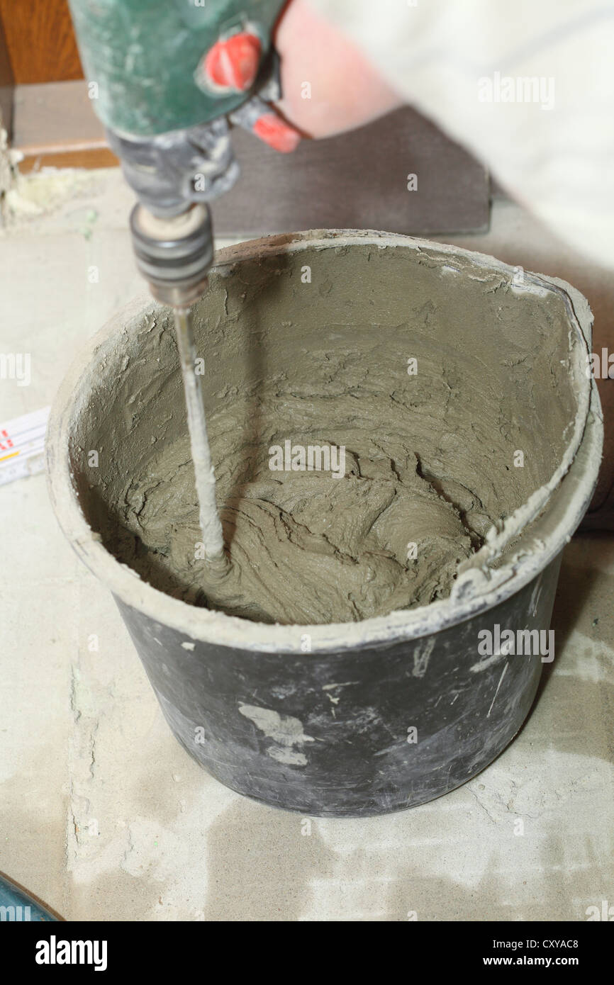 Builder mixing cement mortar in bucket Stock Photo Alamy