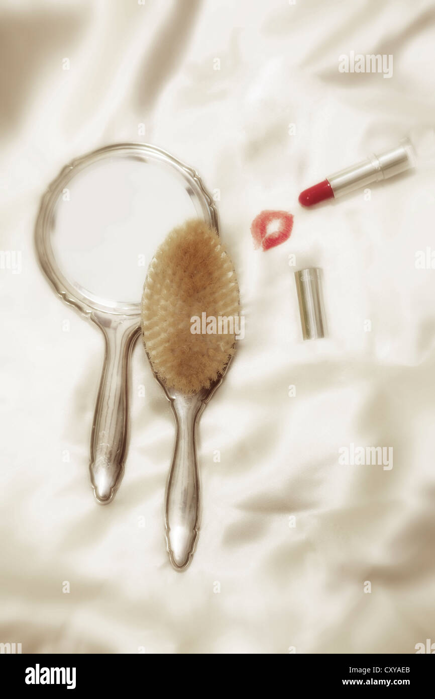an old hand mirror with lipstick and Brush and kissing lips Stock Photo