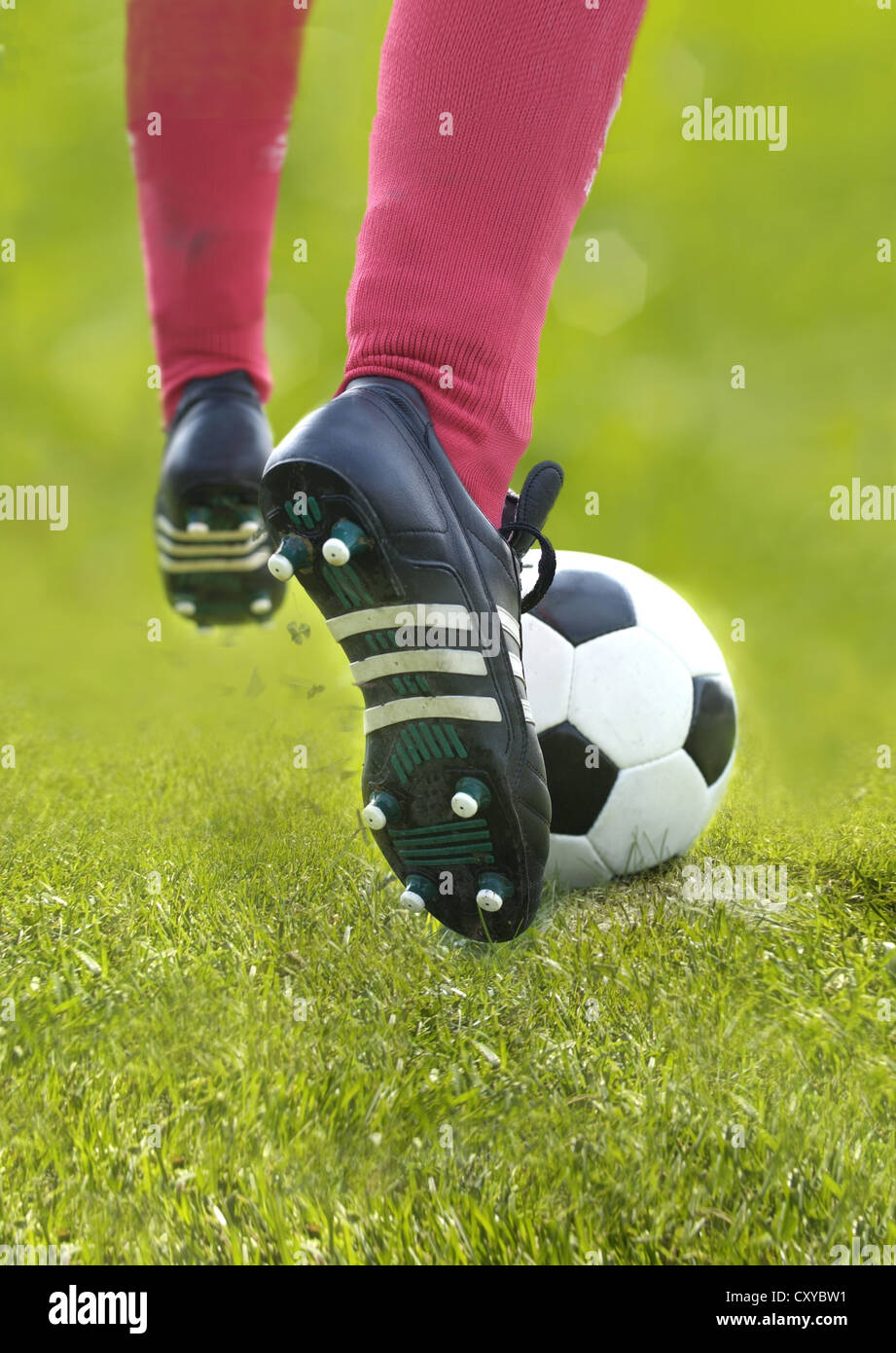 Football player, detail of legs, kicking the ball Stock Photo Alamy