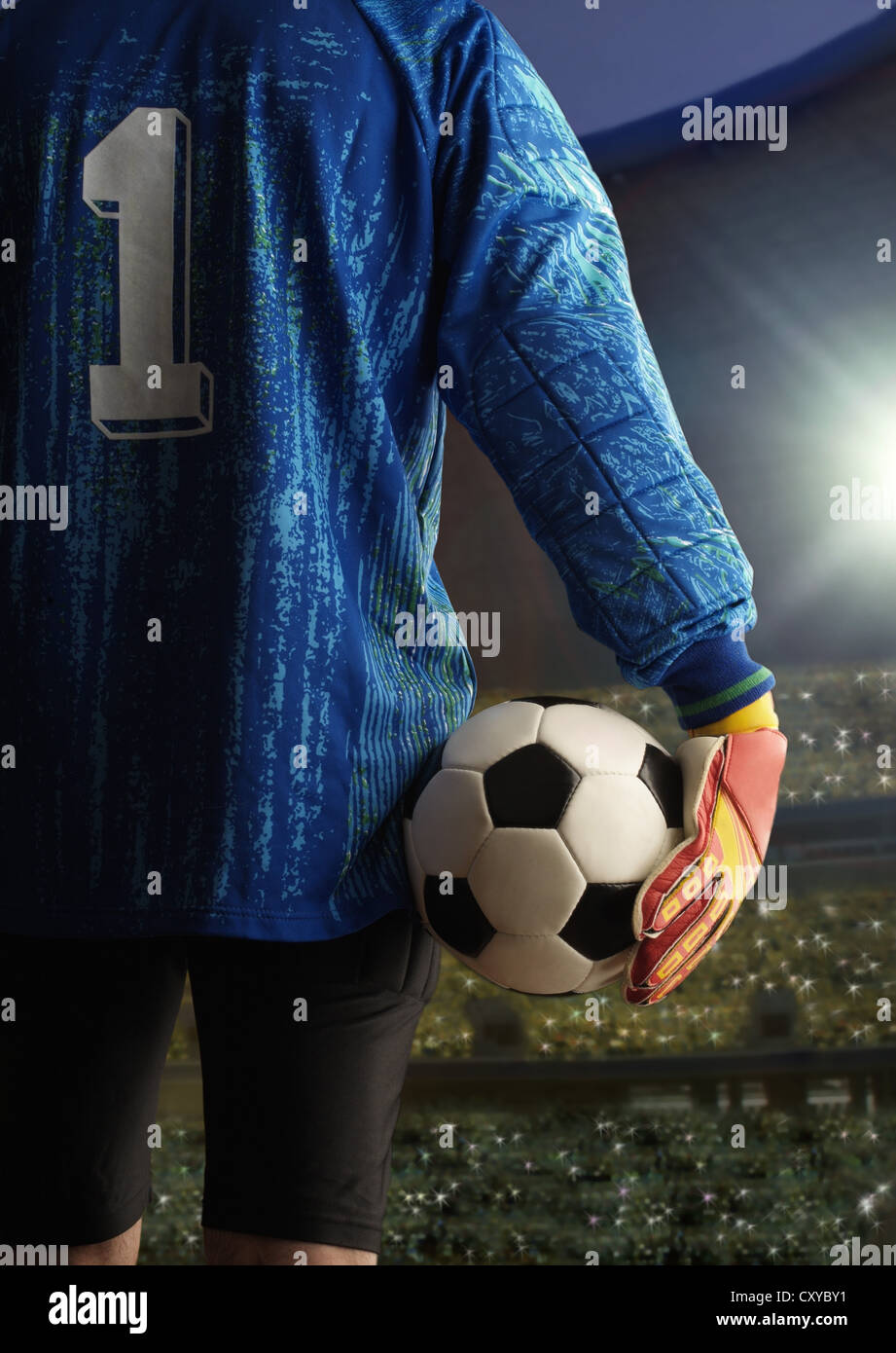 Goalkeeper holding a football, seen from behind, at a football stadium Stock Photo