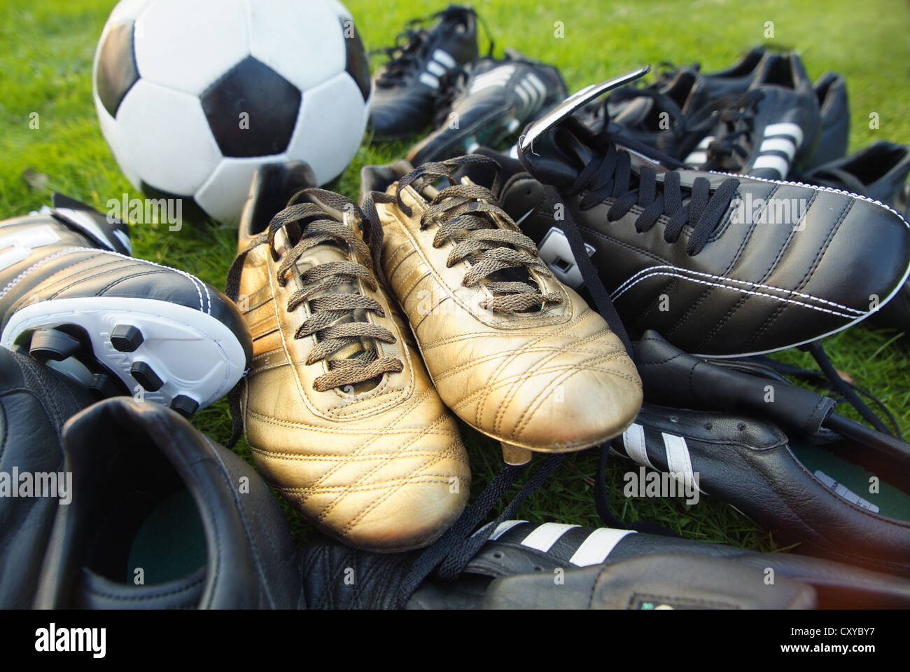 Black and gold football boots with a football Stock Photo