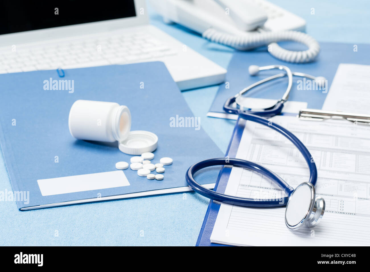 Doctor's office desk with medical supplies documents stethoscope Stock