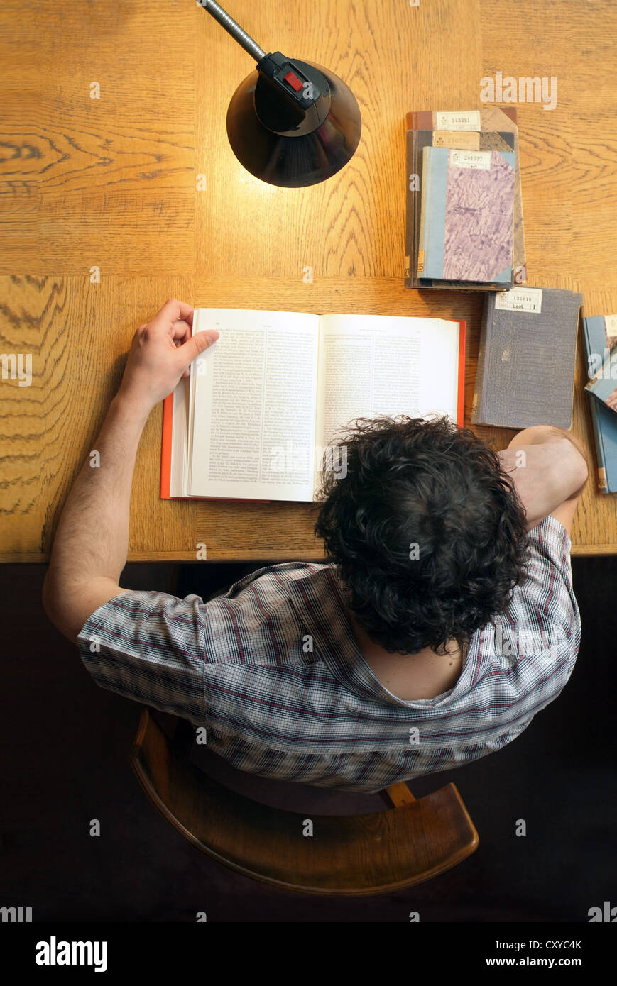 Student sitting at a desk in a university library, view from above ...