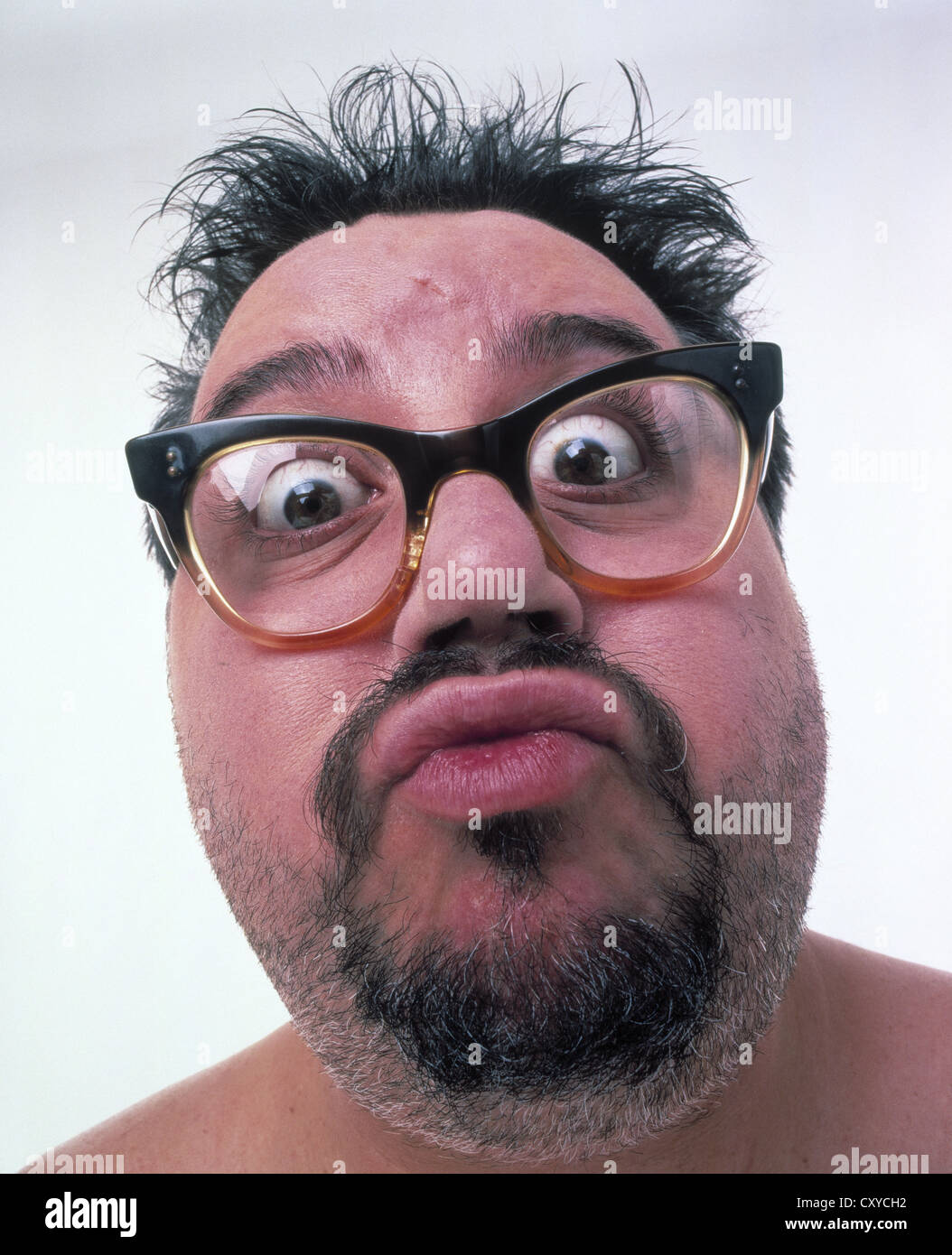 Middle aged fat man wearing glasses, unshaved, with a surprised face