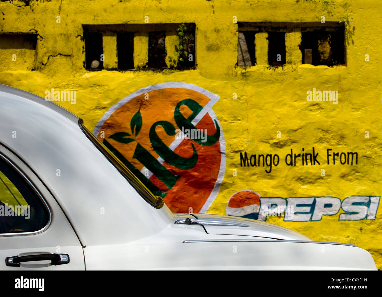 White Ambassador Car In Front Of A Painted Wall With Pepsi Advertising On It, Tirumayam, India Stock Photo