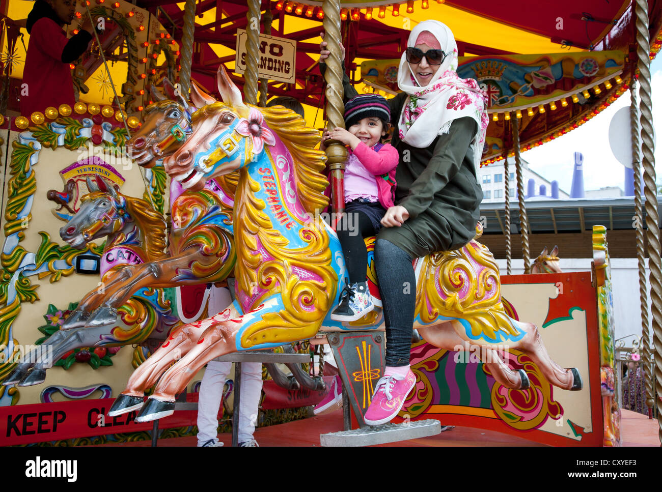 England. London. South Bank. Funfair. Mother and daughter on Carousel pony ride. Stock Photo