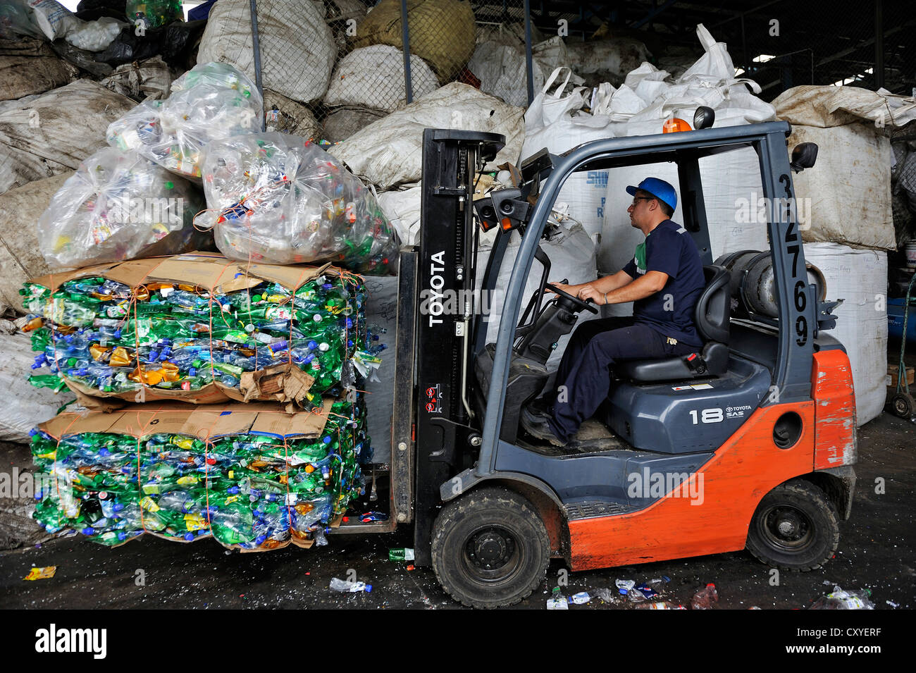Forklift transporting compressed and packaged plastic bottles at a recycling plant for the export to China, San José Stock Photo