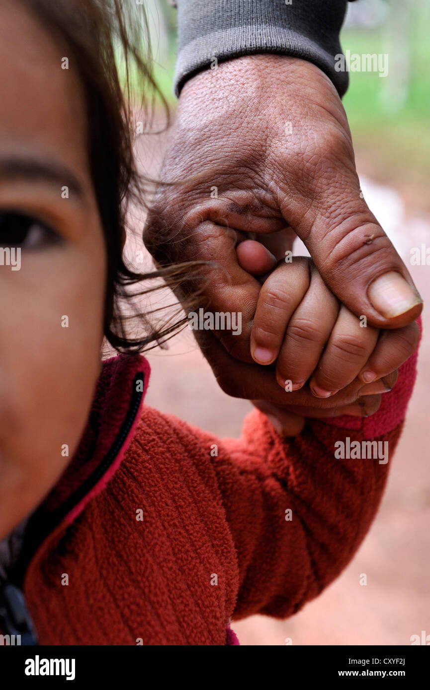 Little girl holding her father's hand, Comunidad Arroyito, Departamento Concepcion, Paraguay, South America Stock Photo