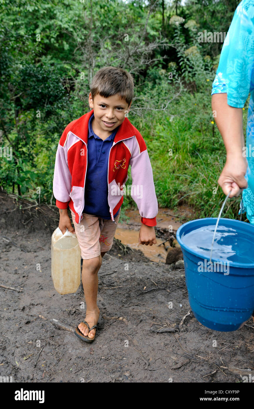 Mother and son fetching water from a stream, Comunidad Martillo, Caaguazu, Paraguay, South America Stock Photo