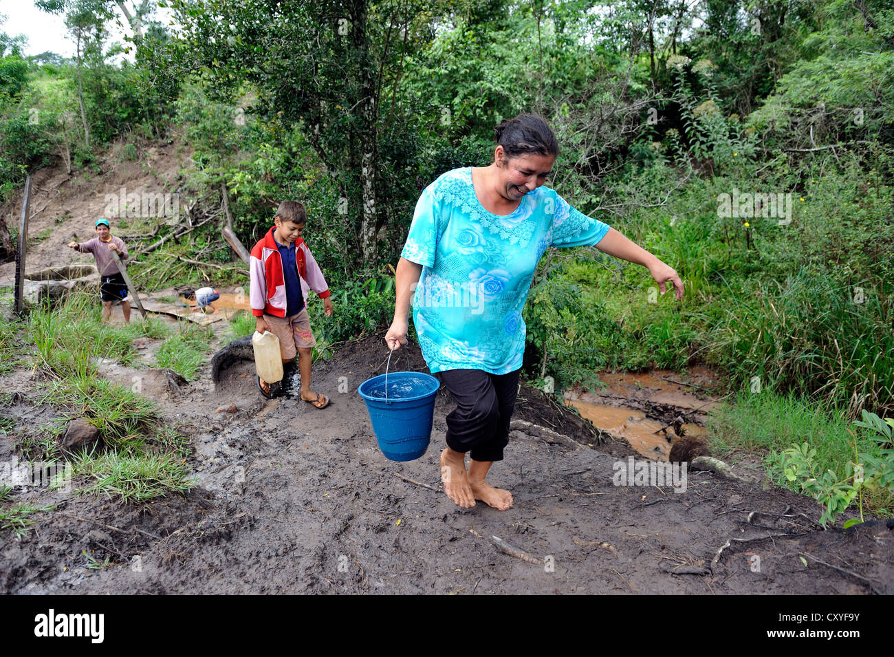 Mother and son fetching water from a stream, Comunidad Martillo, Caaguazu, Paraguay, South America Stock Photo