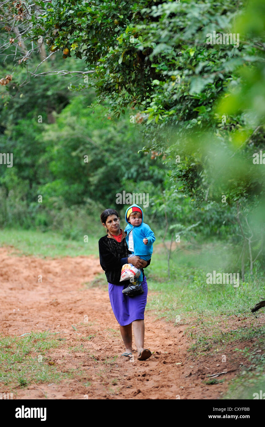 Mother carrying her child in her arms, Comunidad Kinta'i, Caaguazu, Paraguay, South America Stock Photo