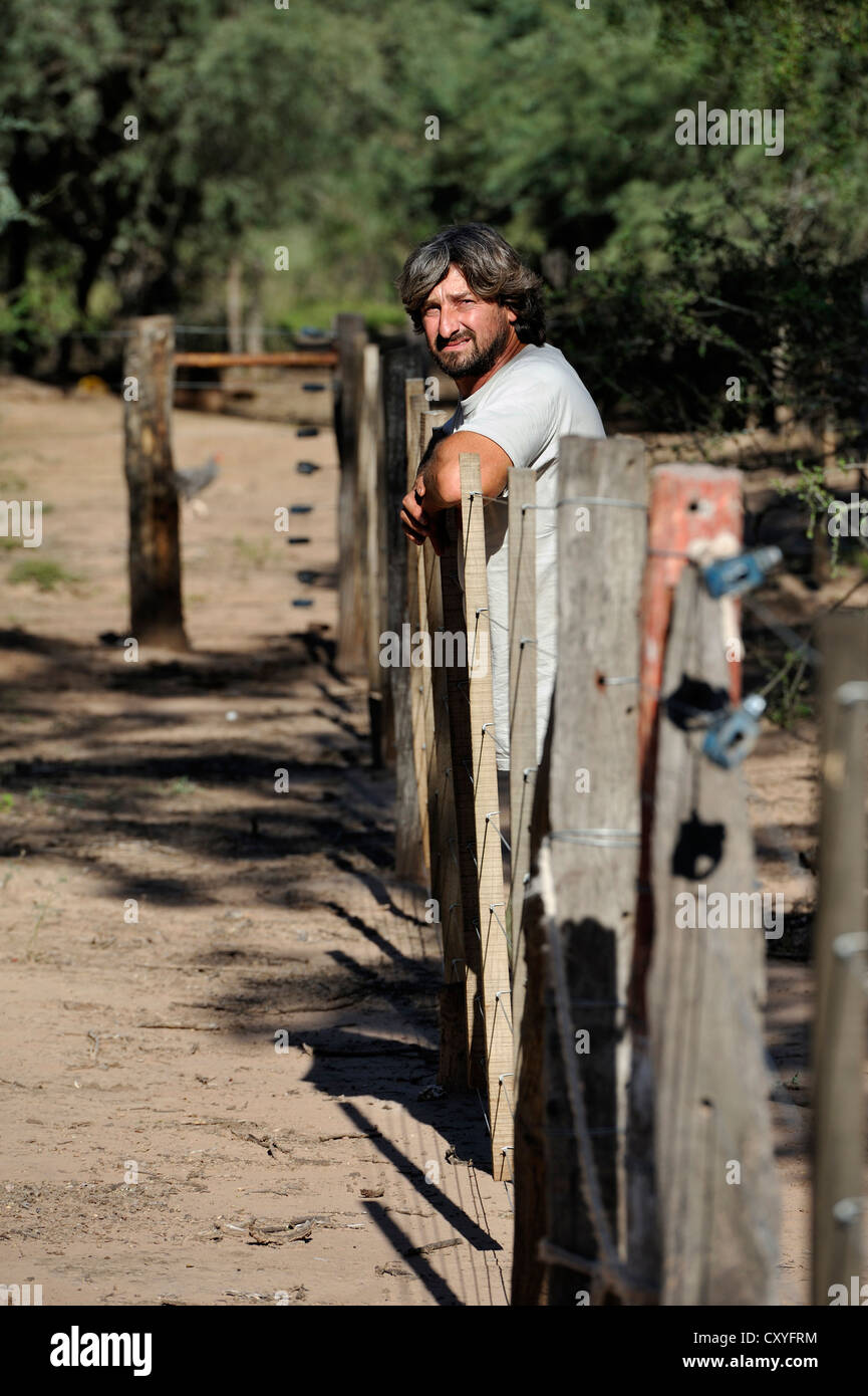 Smallholder at his fence with which he is trying to emphasise the claim to the land cultivated by him, great land owners and Stock Photo
