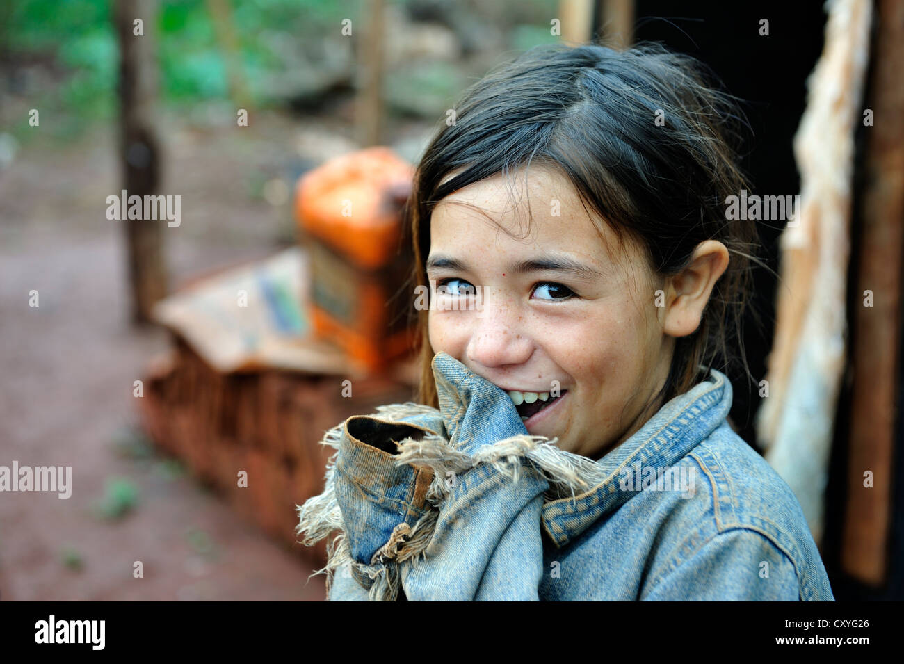 Portrait of a cheeky smiling girl, whose parents were forced off their land alongside dozens of other smallholders and their Stock Photo