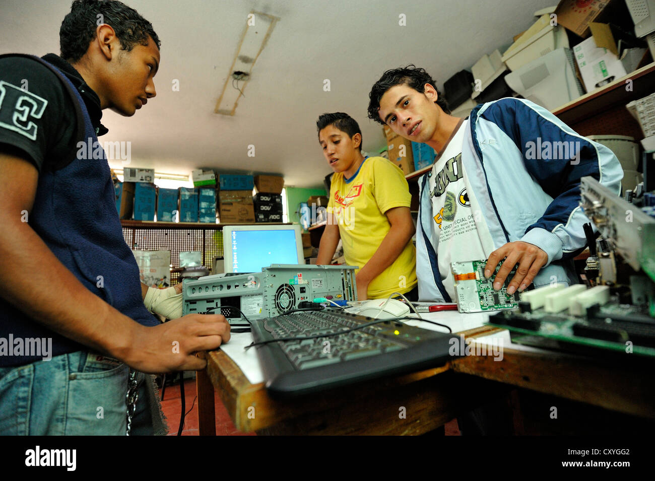 Young people, former hired killers and members of gangs of youths, Maras, learning how to build a working computer from used Stock Photo
