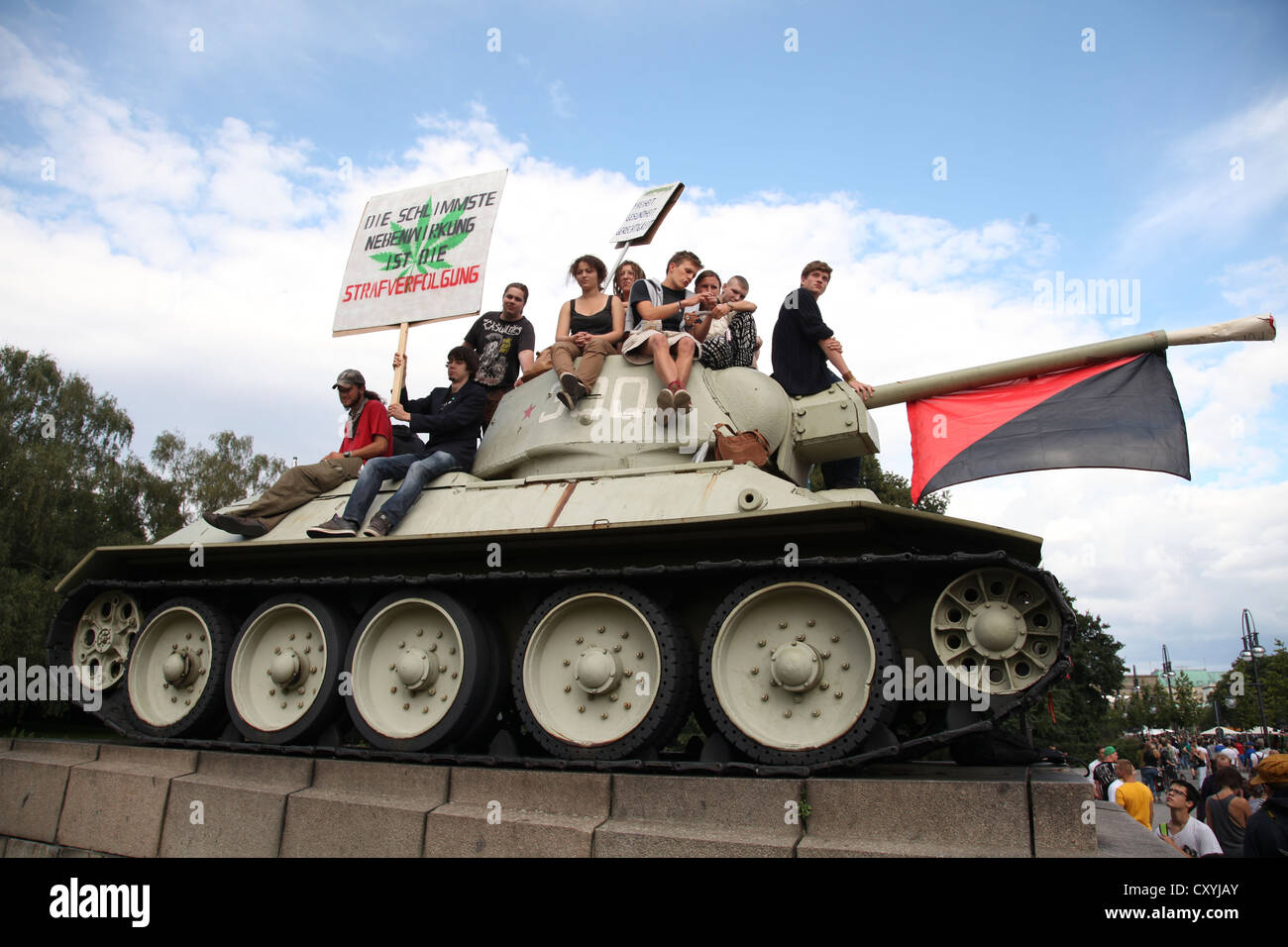 Participants of the Hemp Parade climb a tank at the Soviet War Memorial in Tiergarten, Strasse des 17. Juni, street, protest for Stock Photo