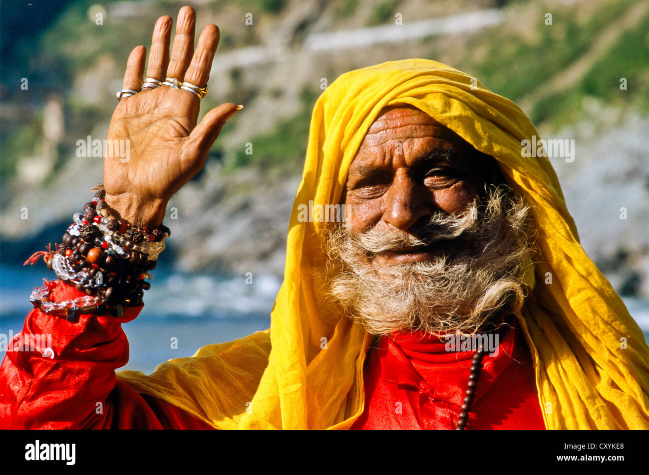 Sadhu, holy man, waving, at the confluence of the holy rivers Baghirati and Alakananda, Devprayag, India, Asia Stock Photo