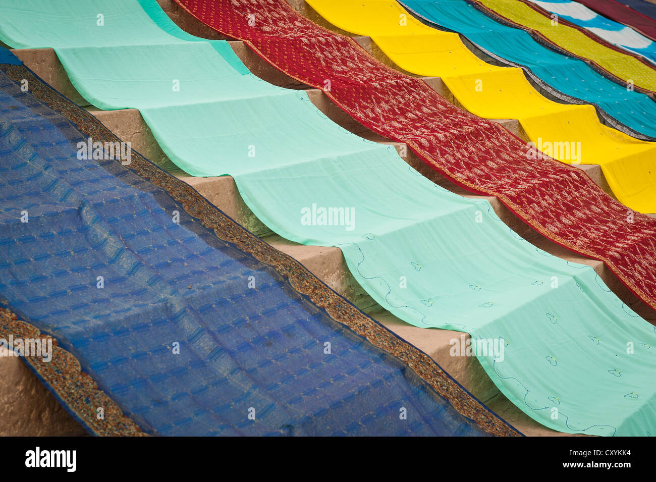 Coloured saris laid out to dry on stairs, ghat, Varanasi also known as Banaras, Uttar Pradesh, India, Asia Stock Photo