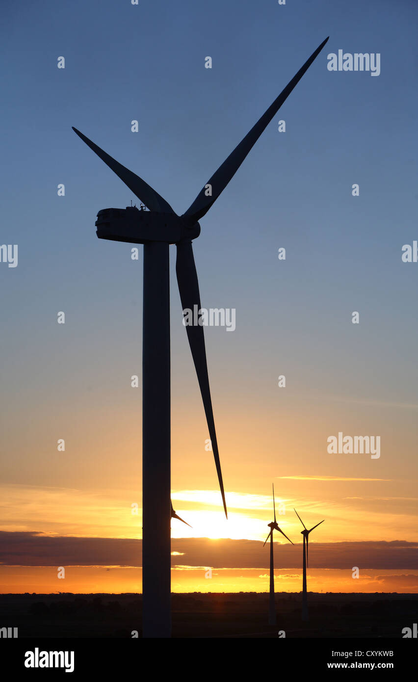 Silhouette of a wind turbine against a colorful sunset Stock Photo - Alamy