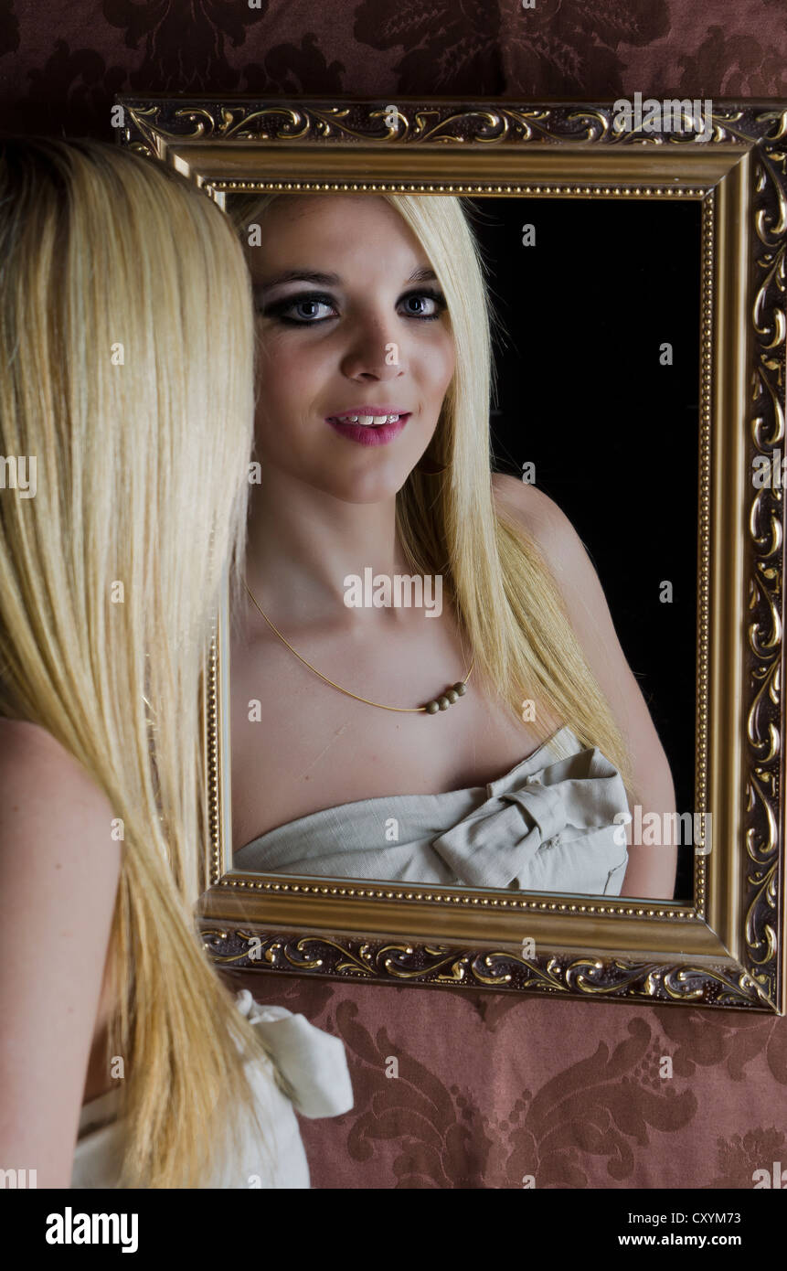 Young woman, 23, looking at herself in the mirror Stock Photo