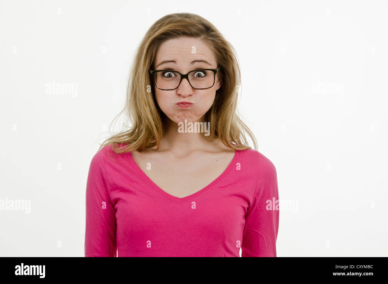 Young woman, 25, wearing large glasses, with puffed cheeks Stock Photo