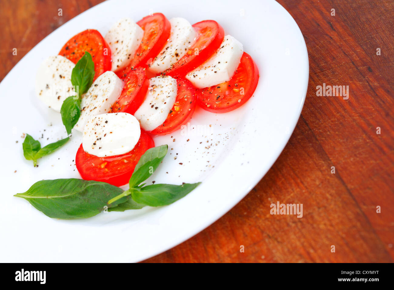Mozzarella cheese tomato and basil on a plate Stock Photo Alamy