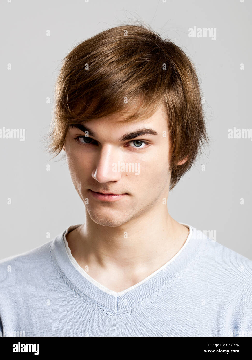 Portrait of a handsome young man over a gray background Stock Photo - Alamy
