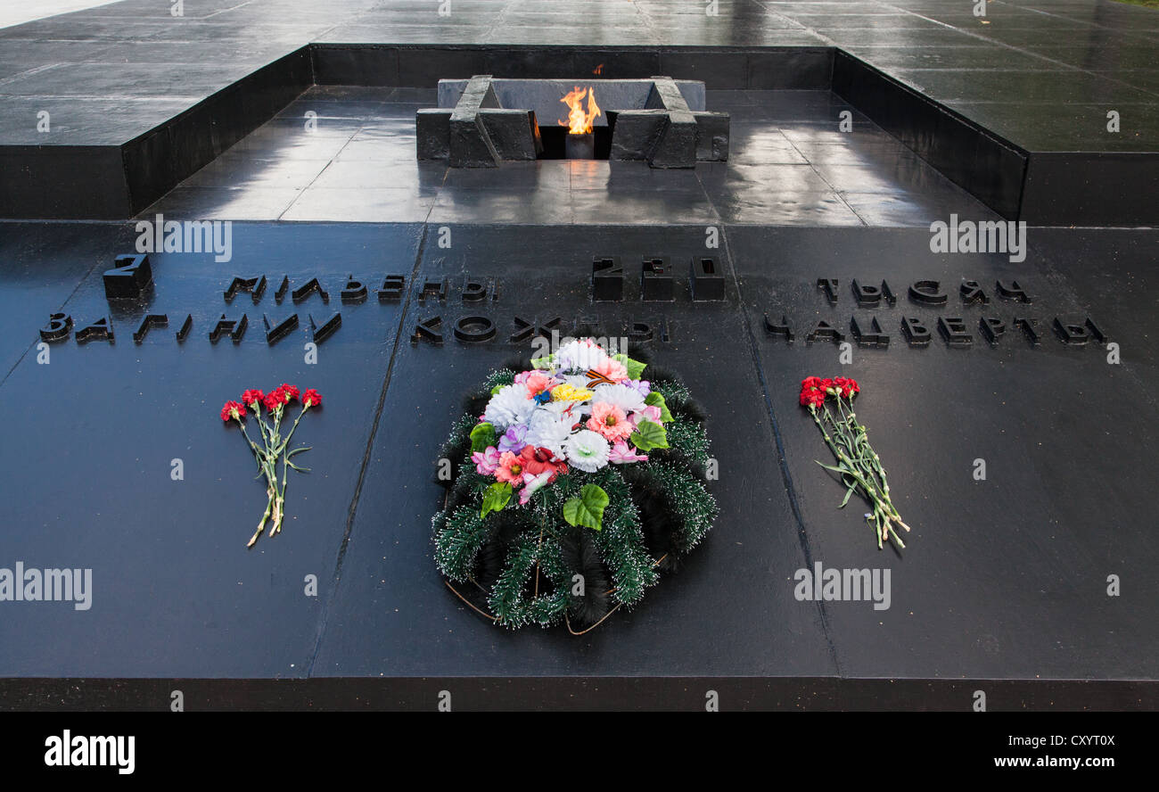 Flowers by the eternal flame, Khatyn Memorial, built to remember the Belarussian fallen of the Great Patriotic War. Stock Photo