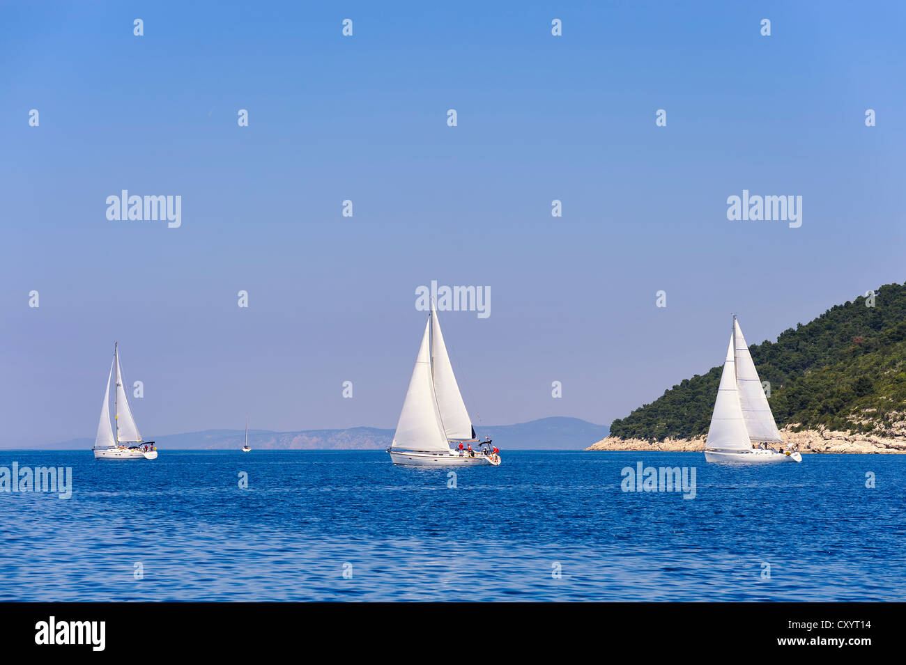 Three sailing yachts going round Cape Kabal on the Croatian island of Hvar, Croatia, Europe