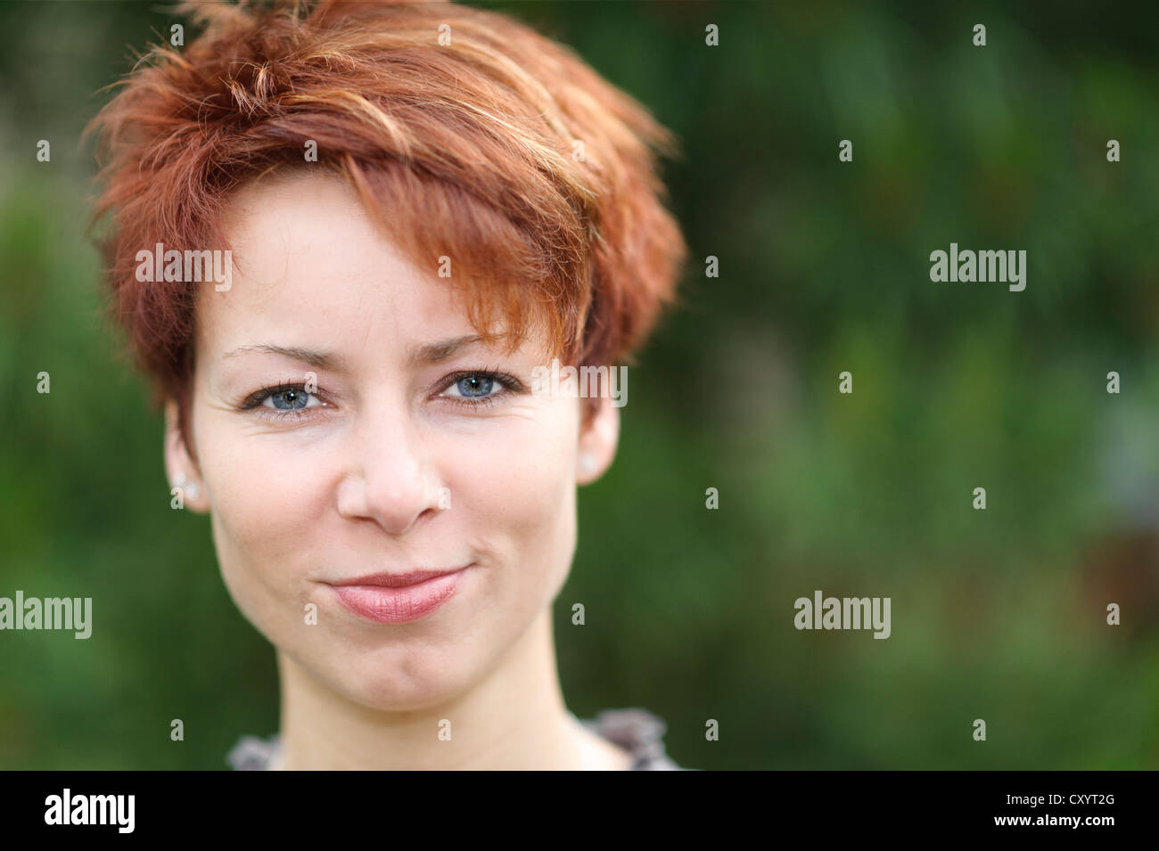 Smiling young woman with short red hair, portrait Stock Photo