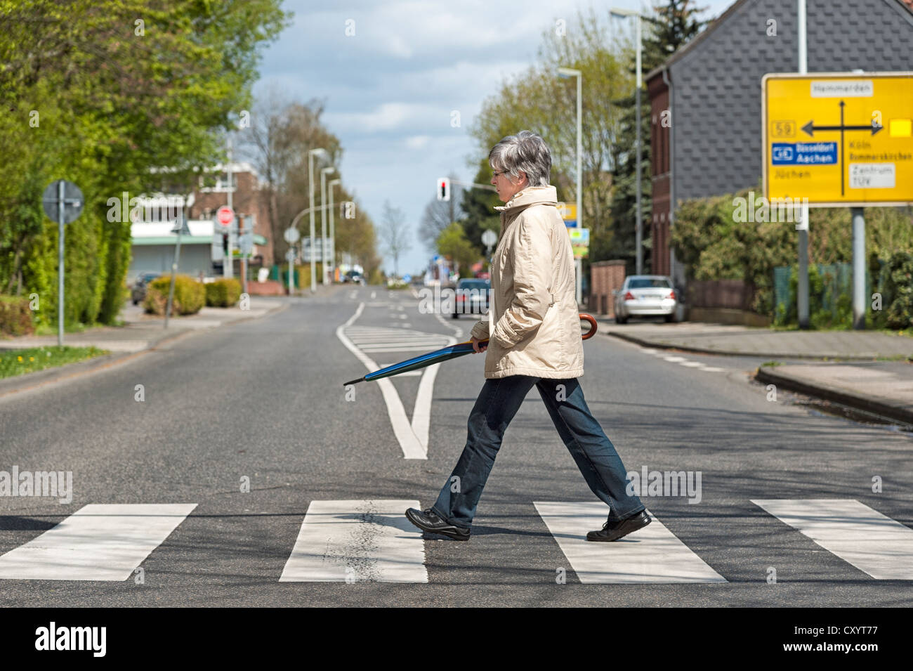 Woman crossing the street at a zebra crossing, Grevenbroich, North Rhine-Westphalia Stock Photo
