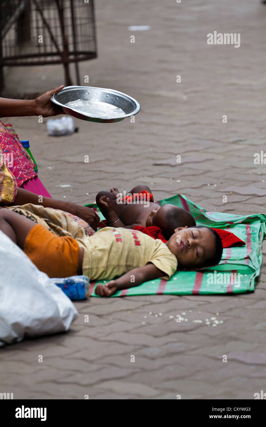 Sleeping Children on the Street in Kolkata while Mother is begging, India Stock Photo