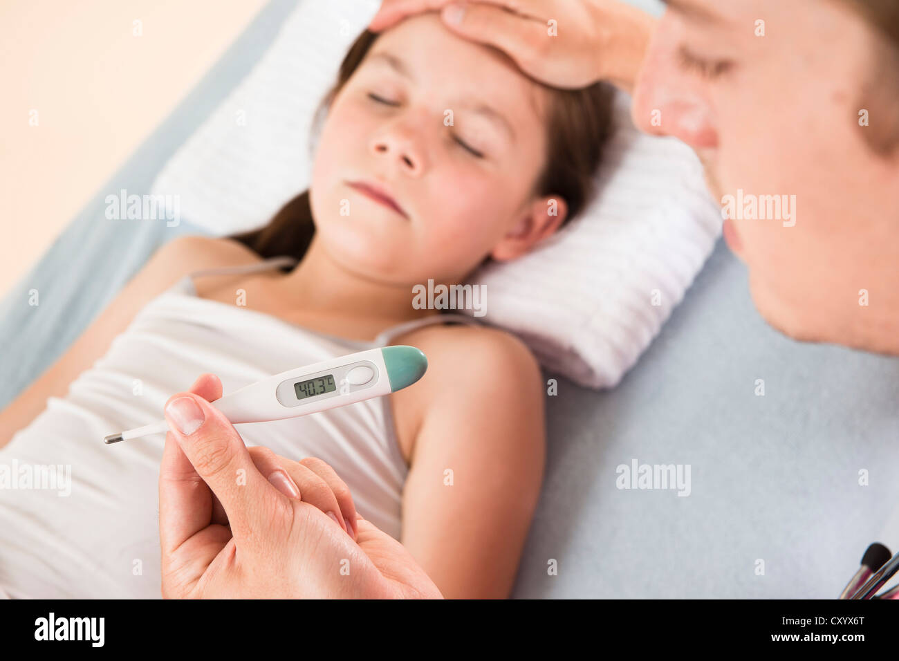 Fever, a pediatrician reading a digital fever thermometer showing concern about the high temperature of a young girl Stock Photo