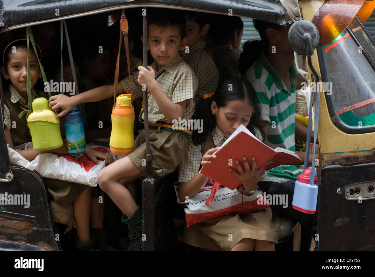 Schoolchildren ride to school in an auto-rickshaw in Mathura, India Stock Photo