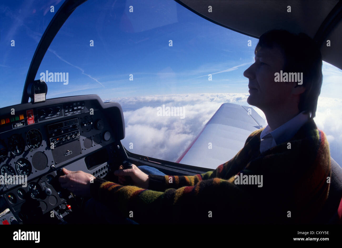Pilot flying over Cumulus clouds on VFR on top flight with a Robin DR