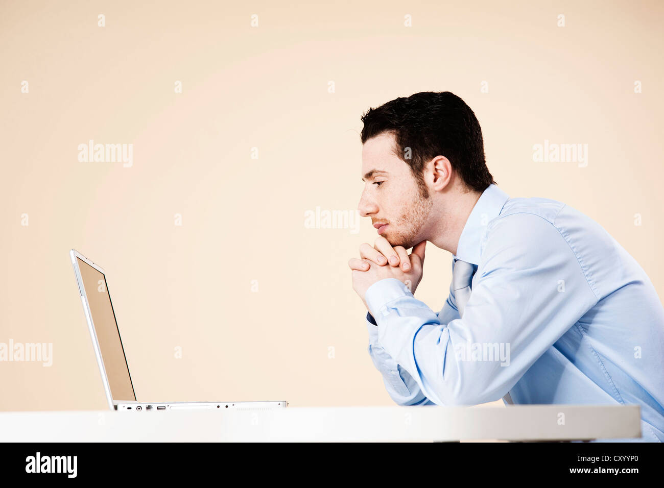 Young manager sitting pensively at his notebook Stock Photo