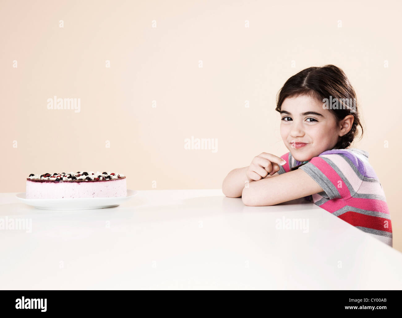 Smiling girl with a cake in front of her Stock Photo - Alamy