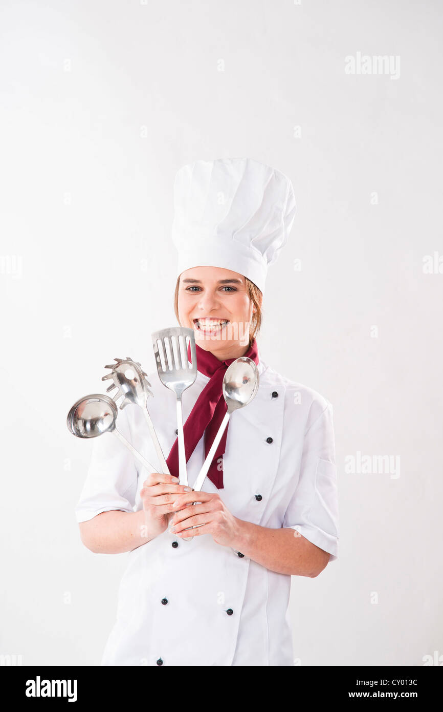 Young chef holding kitchen utensils Stock Photo Alamy