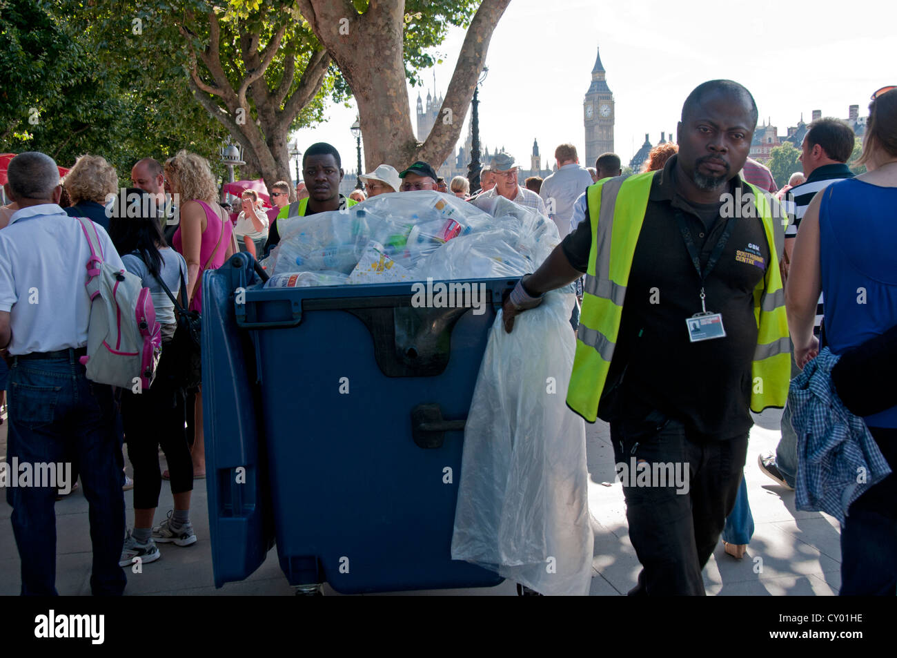 Street cleaners with garbage bin cleaning up on London embankment after