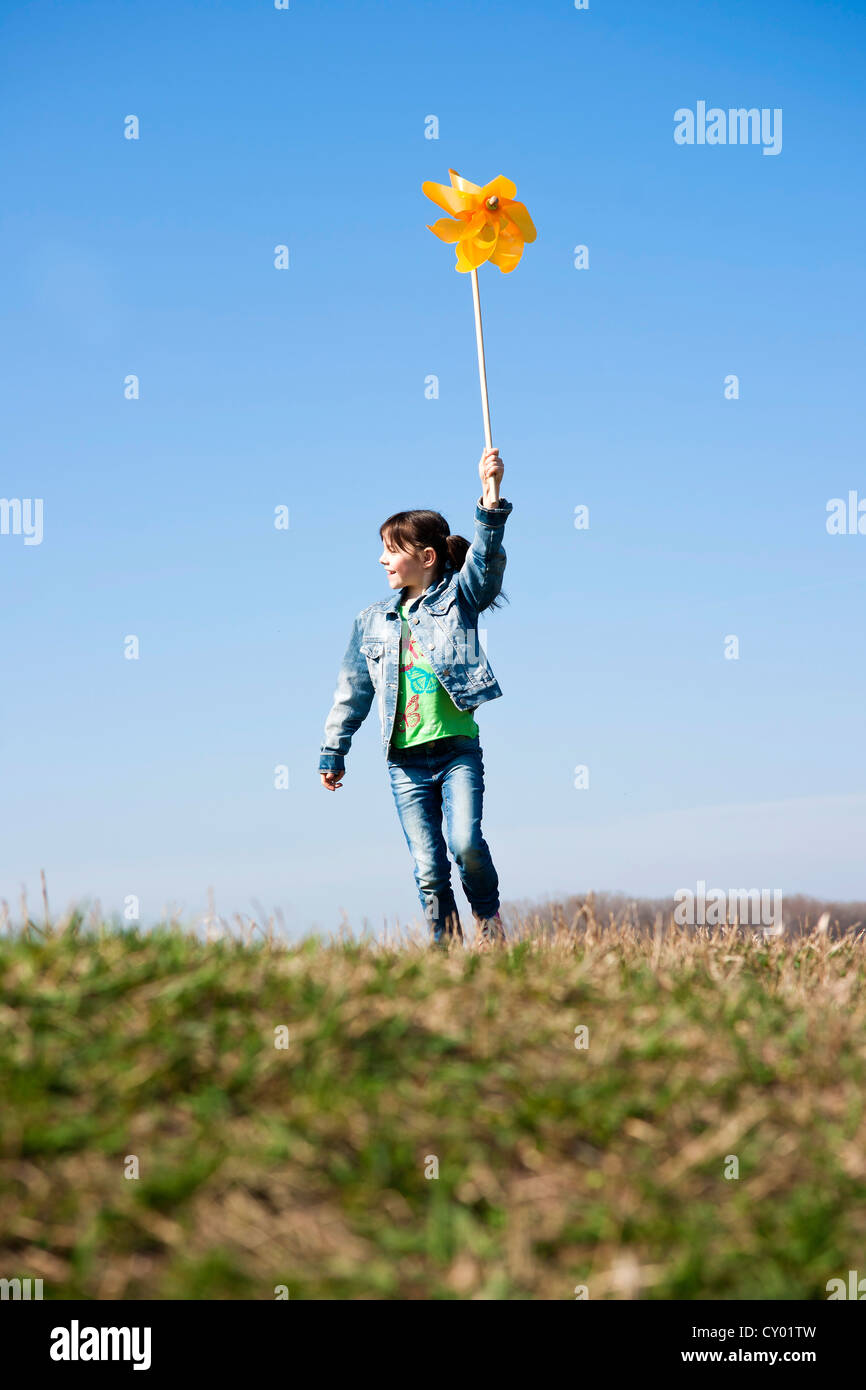 Girl holding up a pinwheel in a field Stock Photo - Alamy