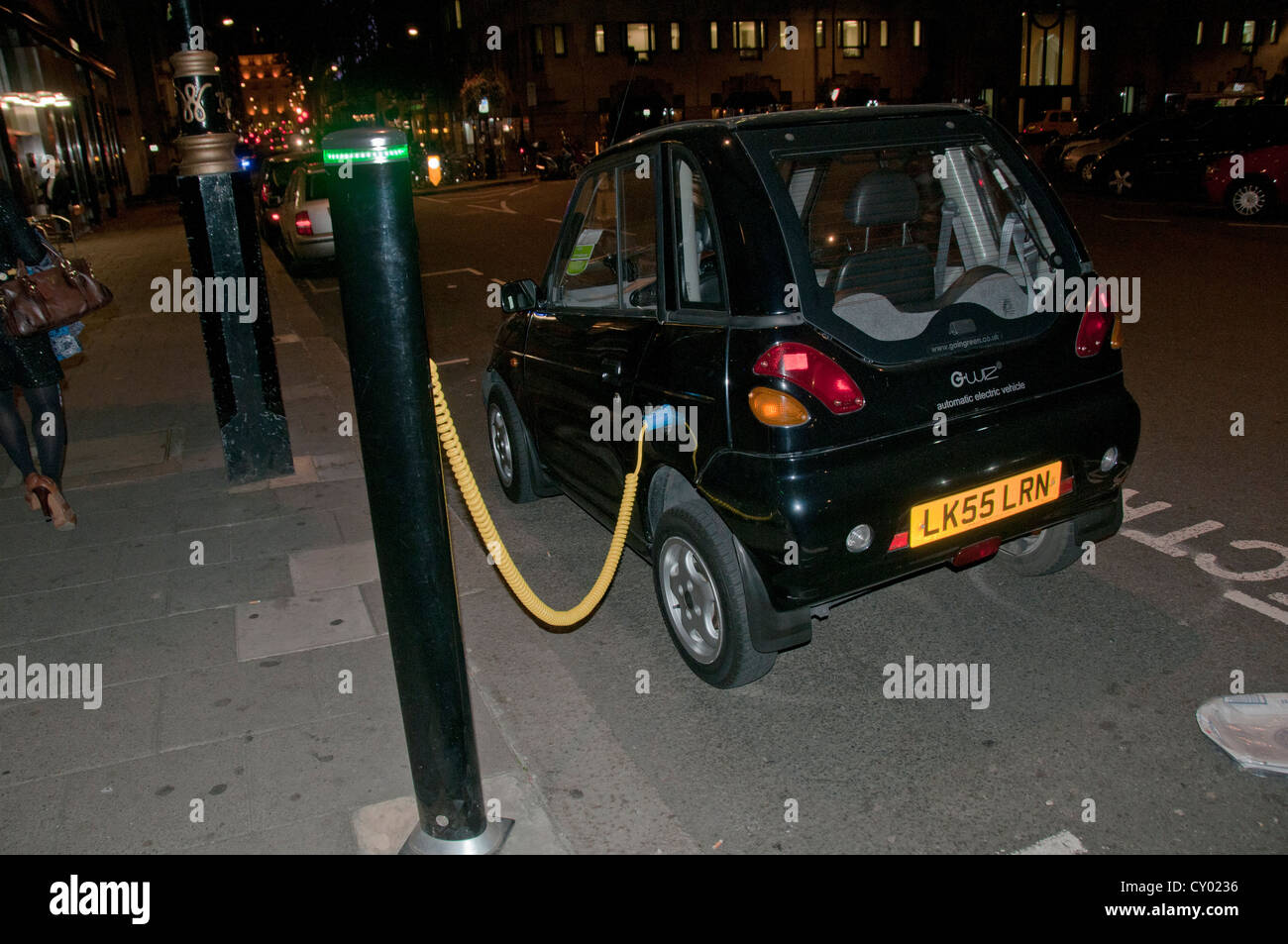 An electric G-Wiz car on charge in central London at night Stock Photo