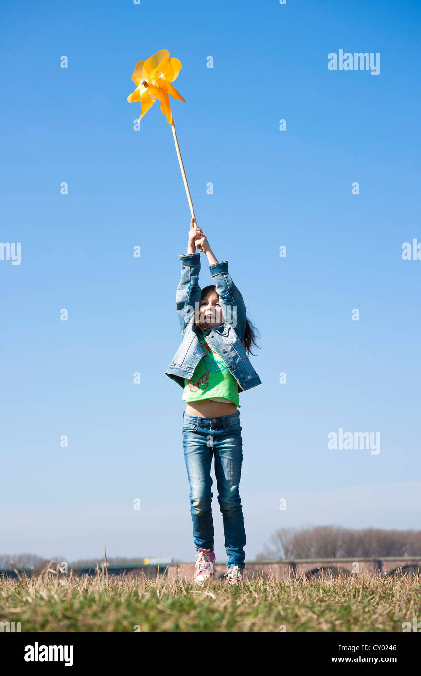 Girl holding up a pinwheel in a field Stock Photo - Alamy
