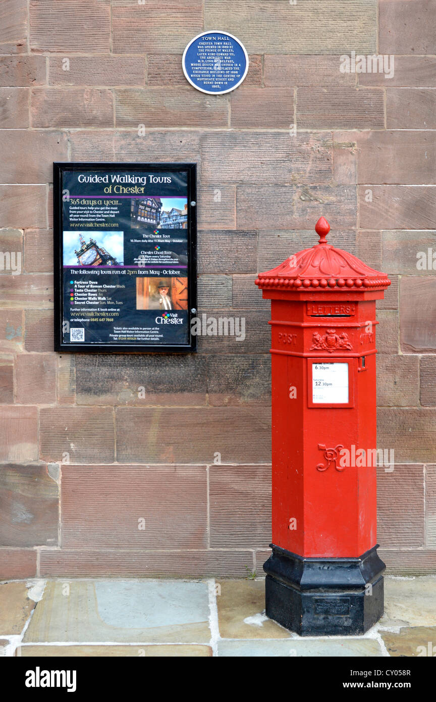 Victorian Royal Mail red pillar box outside town hall with advert for walking tours and blue plaque Chester Cheshire England UK Stock Photo